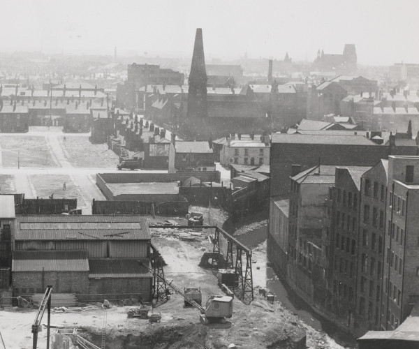 Aerial photograph showing high-density terraced housing, a church, and larger industrial brick buildings.