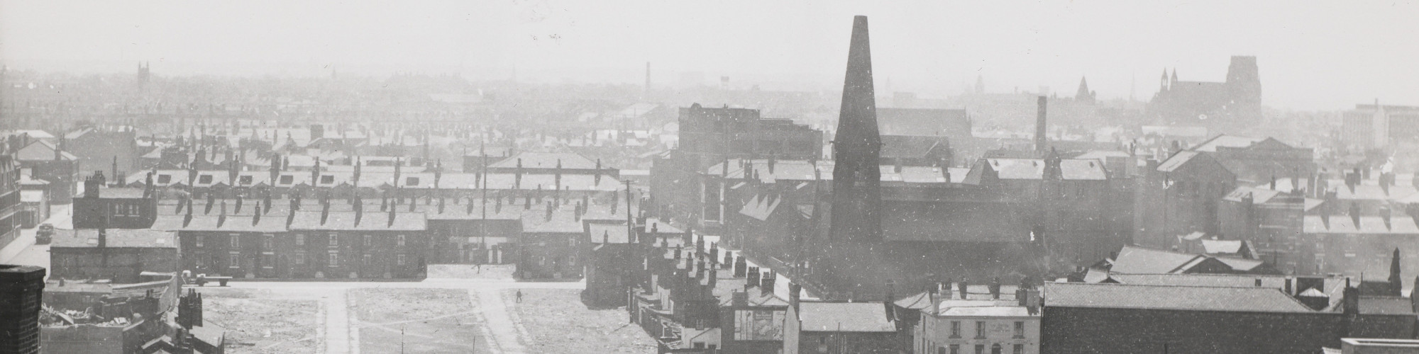 Aerial photograph showing high-density terraced housing, a church, and larger industrial brick buildings.