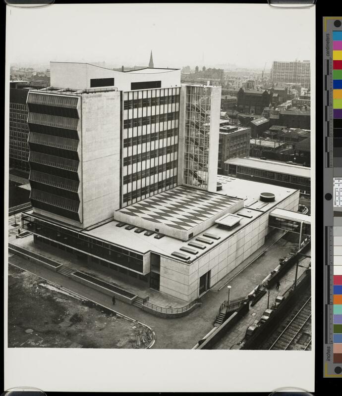 Monochrome photograph of the Renold building, a modernist tower block with a distinctive roof pattern.