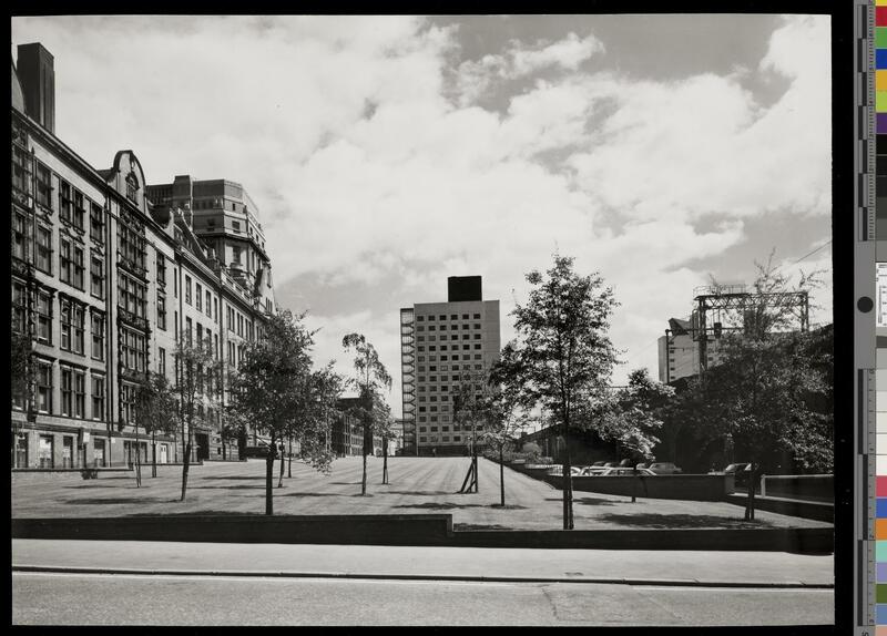 View of Chandos Hall in the distance across a lawn, with the UMIST main building to the left and railway viaducts to the right.