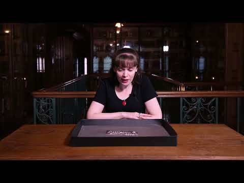 Fran Baker is sat at a table in the John Rylands Research Institute and Library, with a photograph on a tray in front of her.