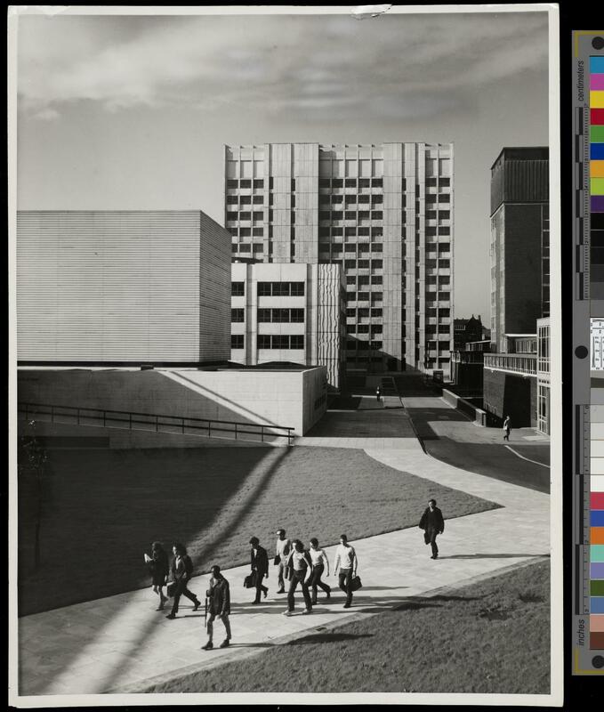 Students walking along a path in the foreground, with the Ferranti and Faraday buildings behind.