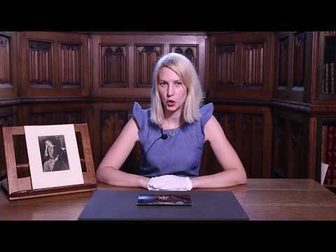 Video showing Anne Anderton sat in a wood panelled room the John Rylands Research Institute and Library, with a photograph resting on a frame beside her. 