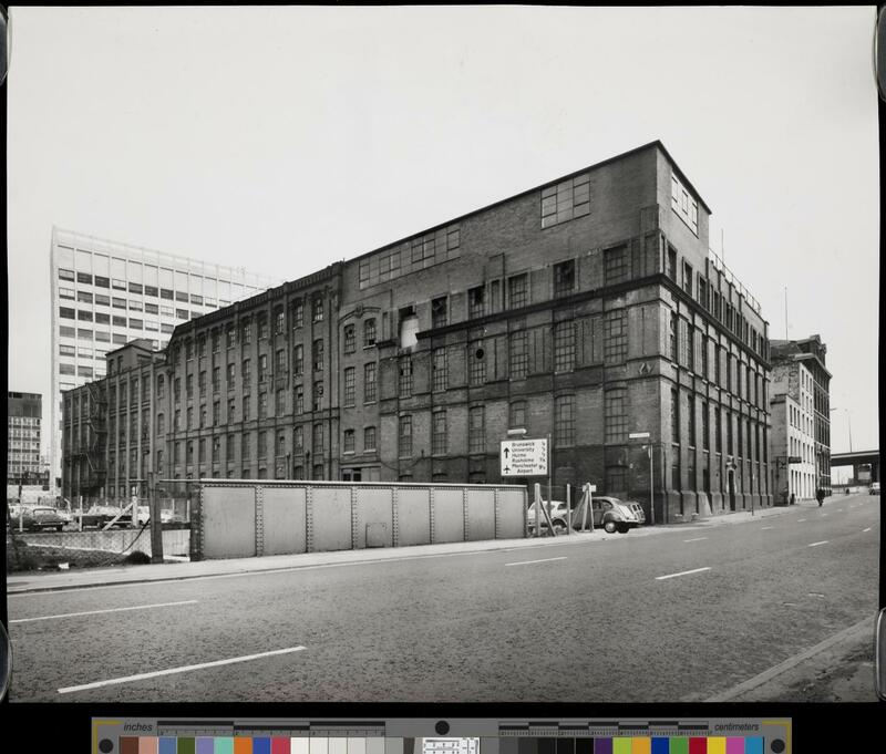 View across a road to the Dunlop Factory, a large Victorian industrial building.